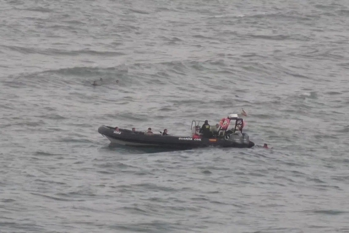 A file photo from July 25, 2025 showing migrants reaching a police boat, as at least 54 children and about 30 adults swam from Morocco to Spain’s North African enclave of Ceuta.