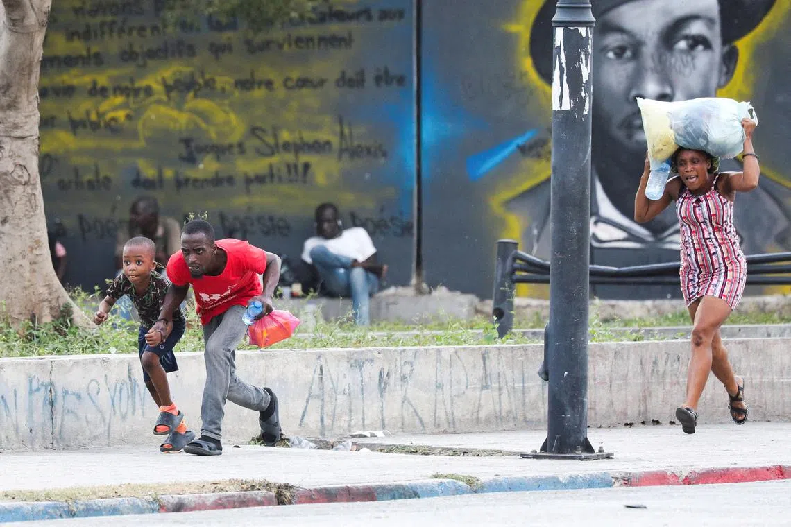 FILE PHOTO: People take cover from gunfire near the National Palace, in Port-au-Prince, Haiti March 21, 2024. REUTERS/Ralph Tedy Erol/File Photo