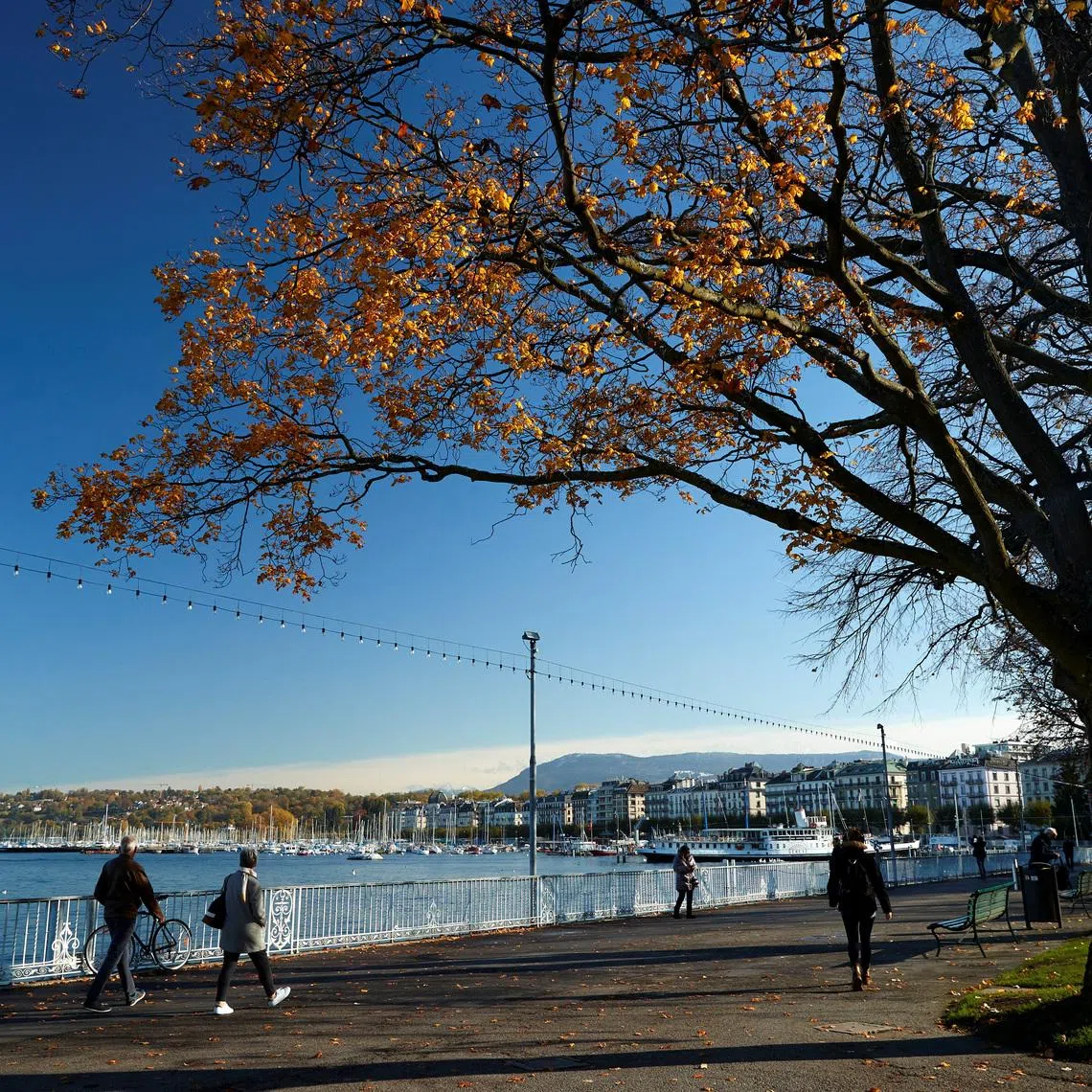 FILE PHOTO: People walk near lake Leamn and the jet d'eau water fountain in Geneva, Switzerland, November 12, 2019. REUTERS/Denis Balibouse/File Photo