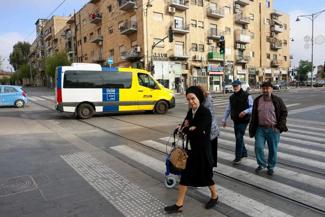 People cross a street in Jerusalem on April 14, 2024. Iran's unprecedented attack on Israel has been "foiled," the Israeli army announced on April 14.