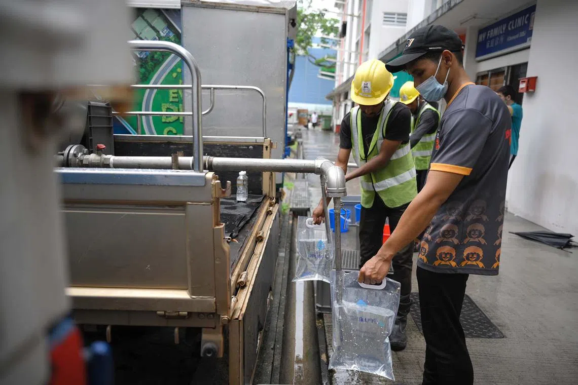 Mr Abdul Rahman, an employee at Western food stall Fatty Bom Bom at Block 325 Clementi Avenue 5, collecting water from one of PUB’s water wagons on Nov 25, 2024, after a water supply to the area was cut off due to a burst water pipe.