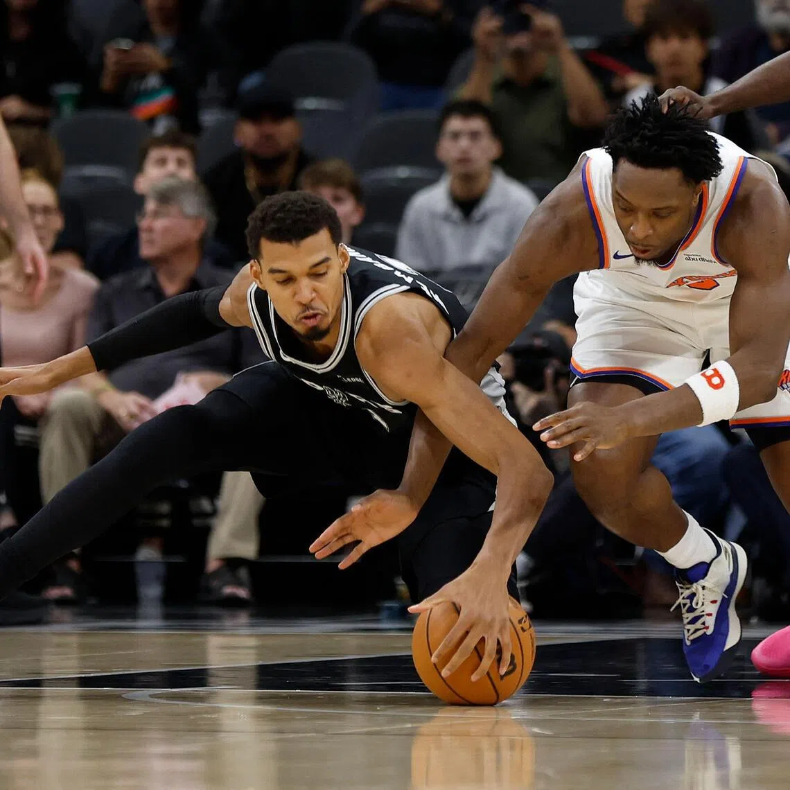 Victor Wembanyama (left) of the San Antonio Spurs fighting for a loose ball with O.G. Anunoby of the New York Knicks in the first half of the Spurs' 134-132 NBA win at Frost Bank Center on Dec 31, 2025, in San Antonio, Texas. 