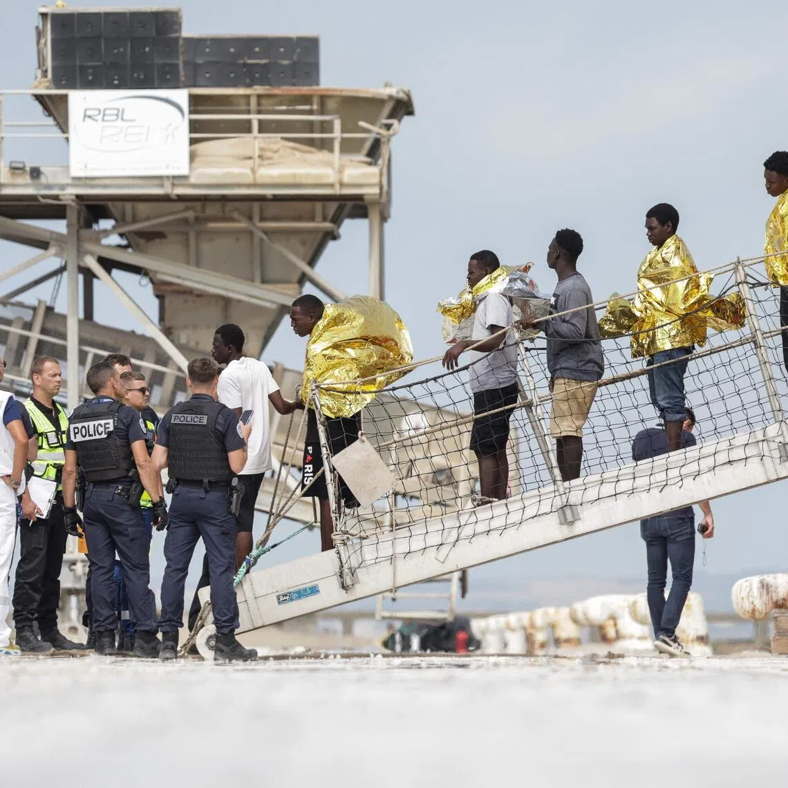 Migrants disembarking from a French ship at the Port de Commerce in Boulogne-sur-Mer, France, on Aug 4, following their rescue at sea after their boat caught fire during an attempt to cross the English Channel from France to Britain.