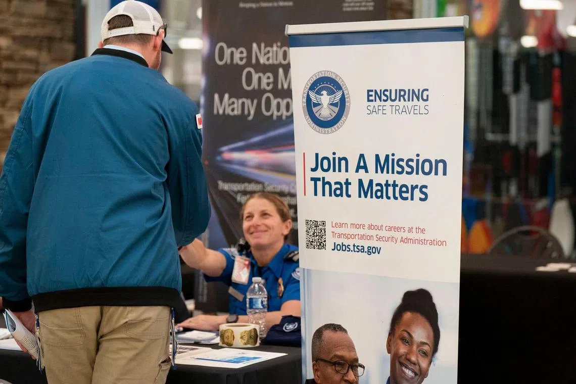 Hiring signage displayed as a hiring representative speaks with a jobseeker at a job and resource fair hosted by the Mountain Area Workforce Development Board in partnership with NCWorks in Hendersonville, North Carolina, US, on Tuesday, Nov. 19, 2024. The Department of Labor is scheduled to release initial jobless claims figures on November 21. Photographer: Allison Joyce/Bloomberg