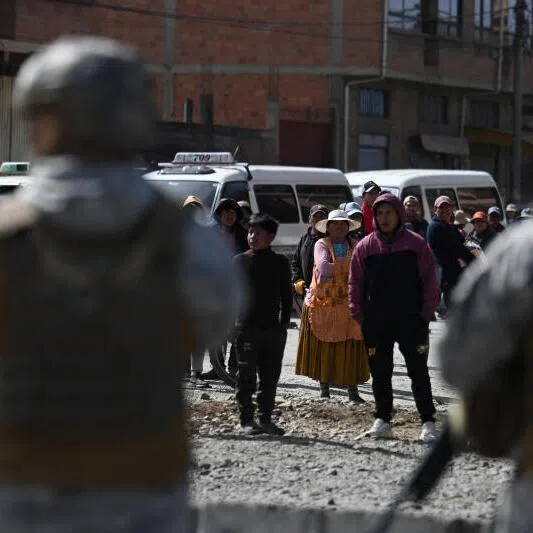 People standing near military personnel on June 20, after Bolivian President Rodrigo Paz declared a nationwide state of emergency following weeks of violence and blockades, in El Alto, Bolivia.
