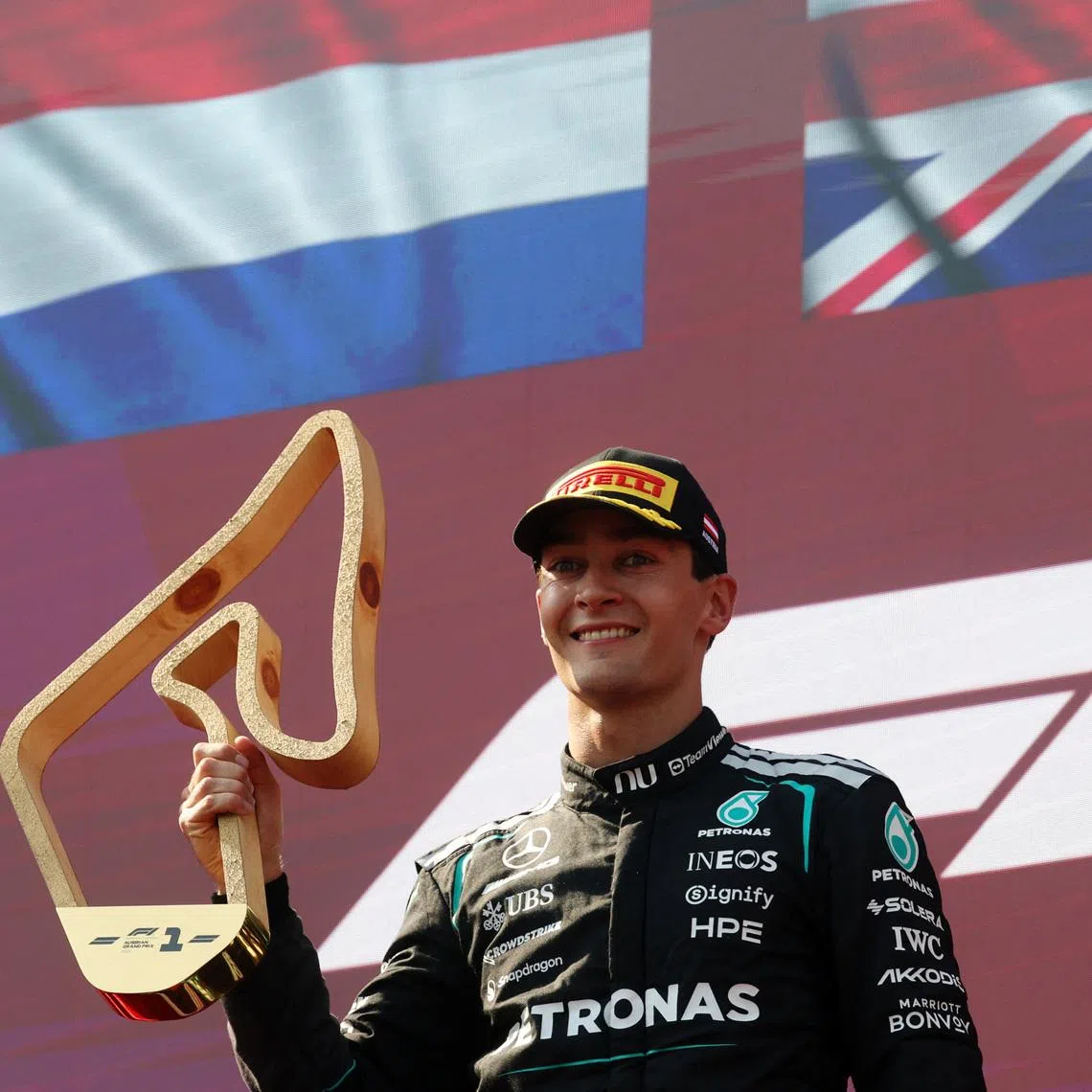 Mercedes’ George Russell celebrates with a trophy on the podium after winning the Austrian Grand Prix on June 28.