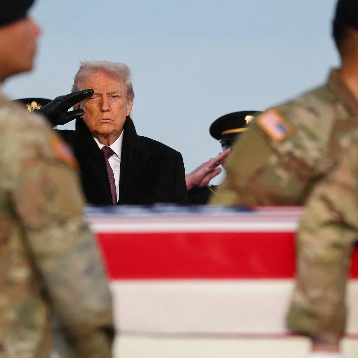 U.S. President Donald Trump salutes, as members of the military carry a transfer case, during a dignified transfer of the remains of two Iowa National Guard members killed in Syria, Sgt. Edgar Torres Tovar and Sgt. William Howard, and Ayad Mansoor Sakat, of Macomb, Michigan, who was working as an interpreter in Syria, at Dover Air Force Base in Dover, Delaware, U.S., December. 17, 2025. REUTERS/Jonathan Ernst