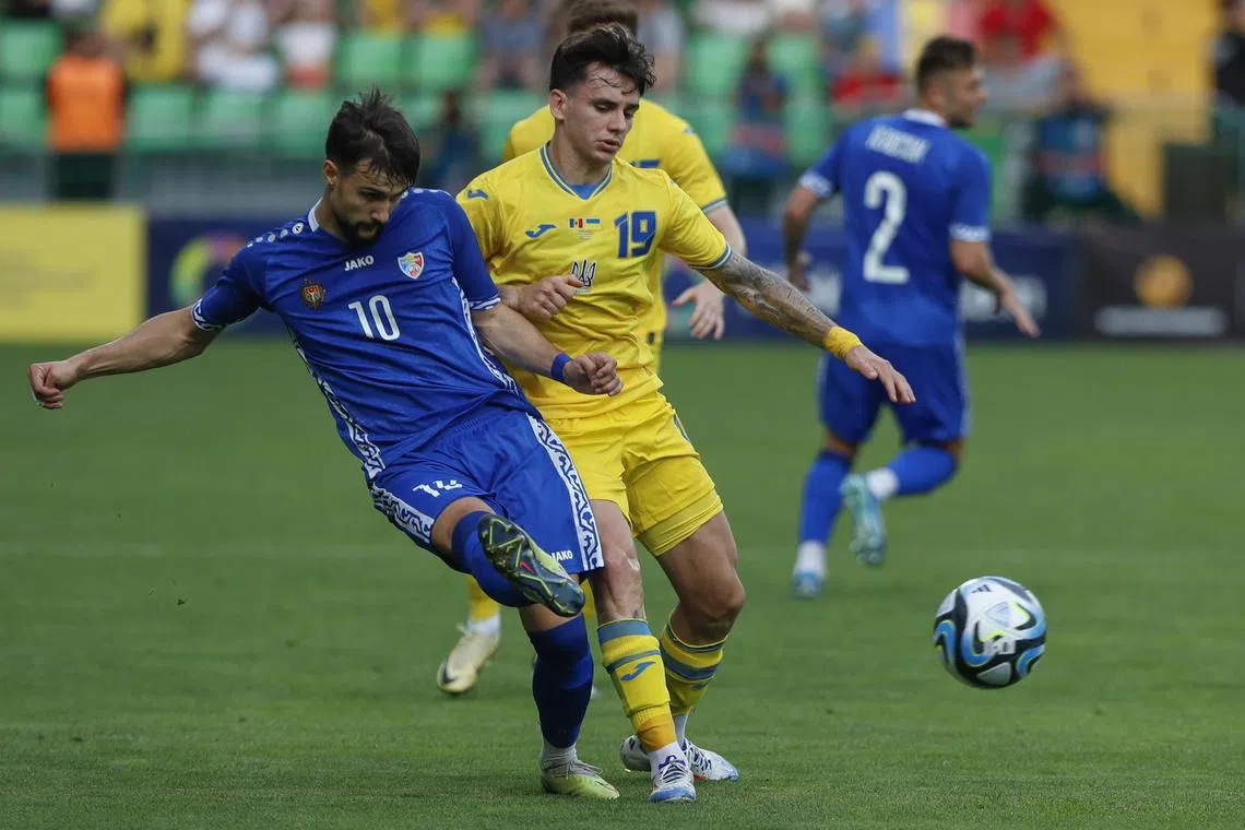 Mykola Shaparenko (in yellow) of Ukraine in action against Vitalie Damascan of Moldova in their friendly match in Chisinau, Moldova on June 11, 2024.