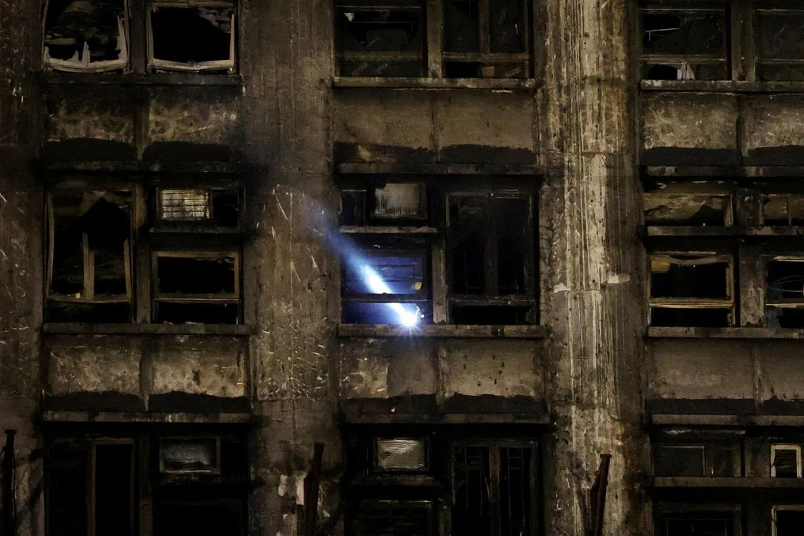 FILE PHOTO: A rescuer works inside a damaged building at the scene after a deadly fire at the Wang Fuk Court housing complex in Hong Kong, China November 27, 2025. REUTERS/Amr Alfiky/File Photo