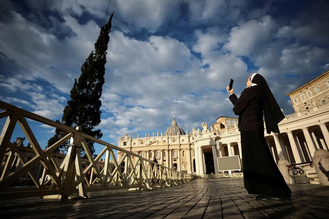 A nun taking a video as a Christmas tree arrives in St. Peter's Square ahead of the festive season at the Vatican, Nov 23, 2023. 