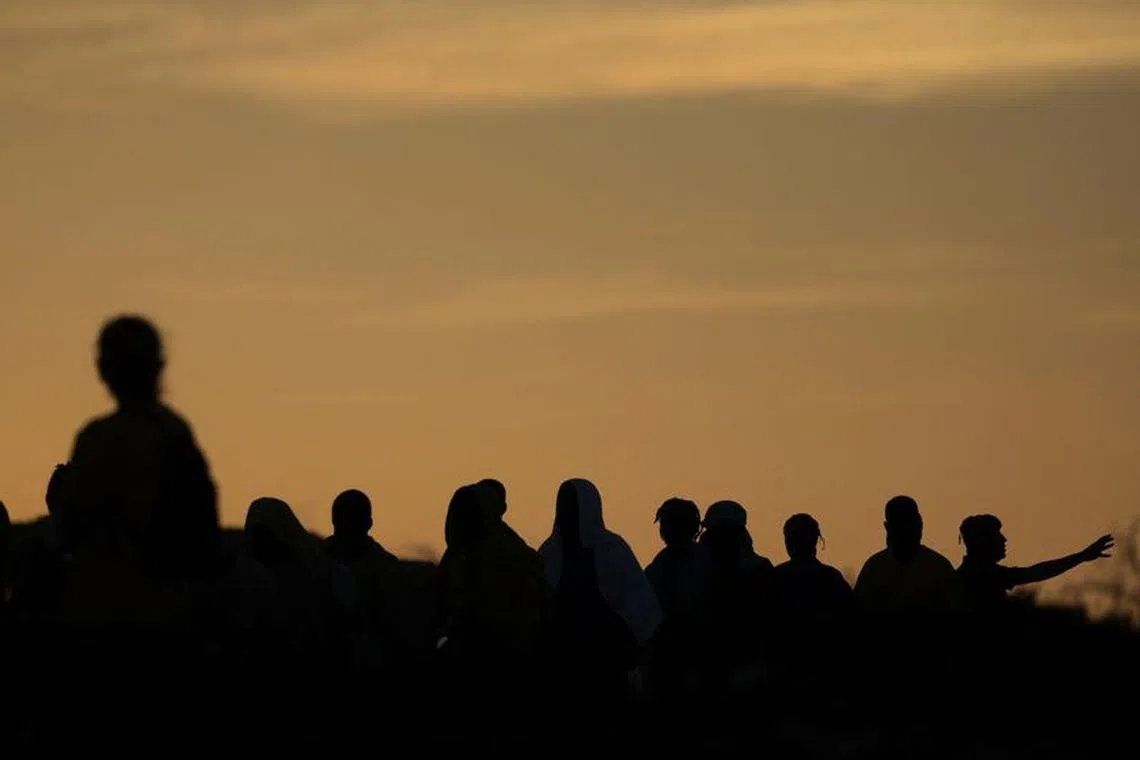 File photo: Migrants are seen in silhouette, as they board a ship to be transferred to the mainland, on the Sicilian island of Lampedusa, Italy, September 15, 2023. REUTERS/Yara Nardi/File photo