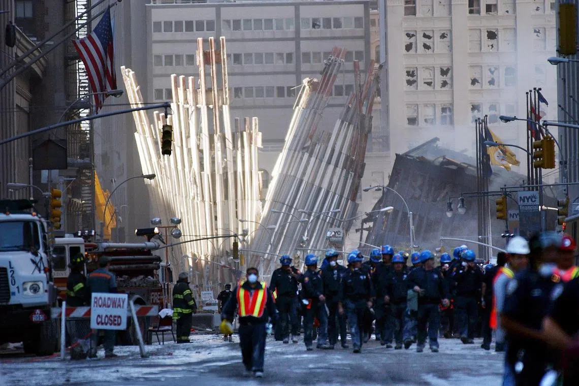 Rescue workers in font of the base of the World Trade Center in New York as search efforts continue on Sept 12, 2001, a day after the attacks.