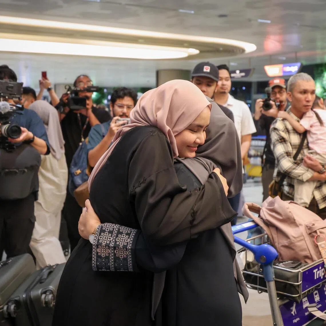 ST20260313_202634800519/vcflight13/Jason Quah

Returnee Ms Raja Nur Syakirah, 21, embracing her mother after returning from Jeddah, at Changi Airport Terminal 2 on March 13, 2026. 

ST PHOTO: JASON QUAH