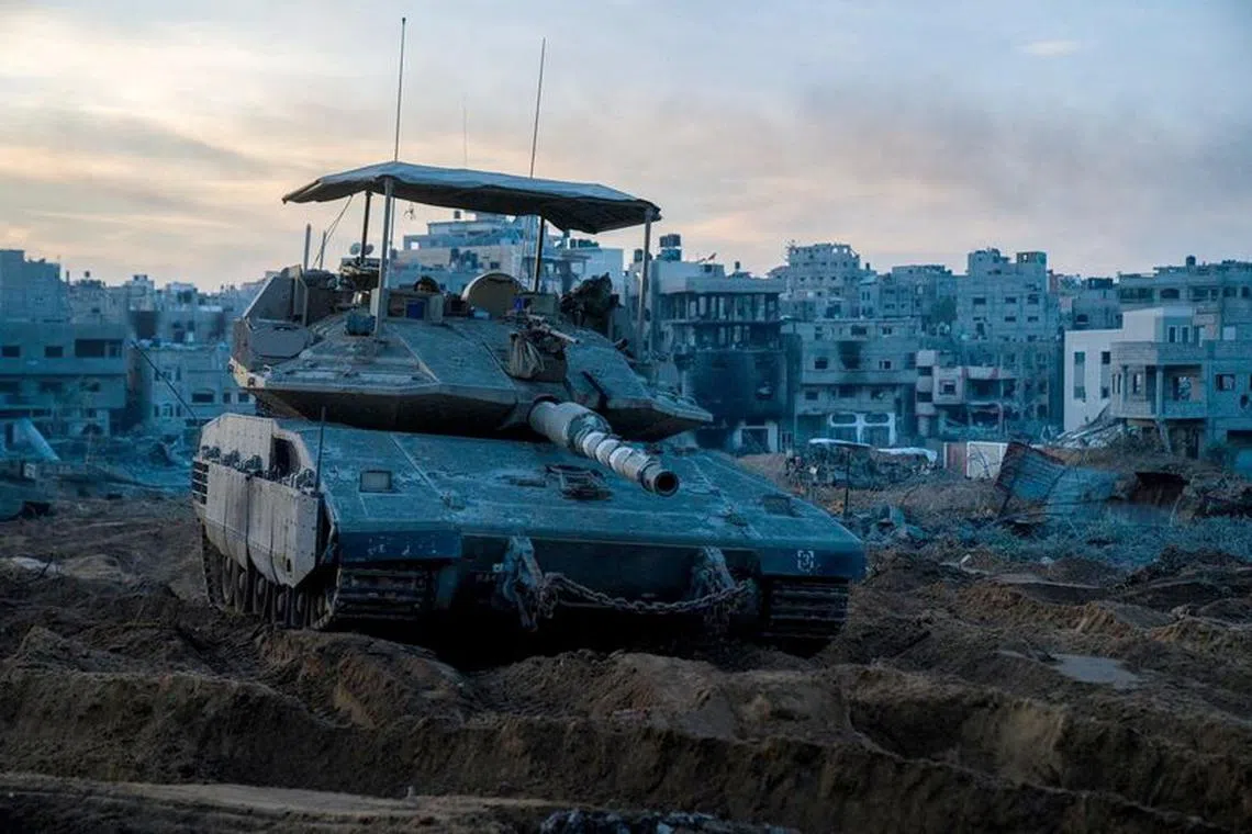 An Israeli soldier looks on from a Merkava tank while operating in a location given as Gaza, amid the ongoing conflict between Israel and the Palestinian Islamist group Hamas, in this handout picture released on December 7, 2023. Israel Defense Forces/Handout via REUTERS/File photo