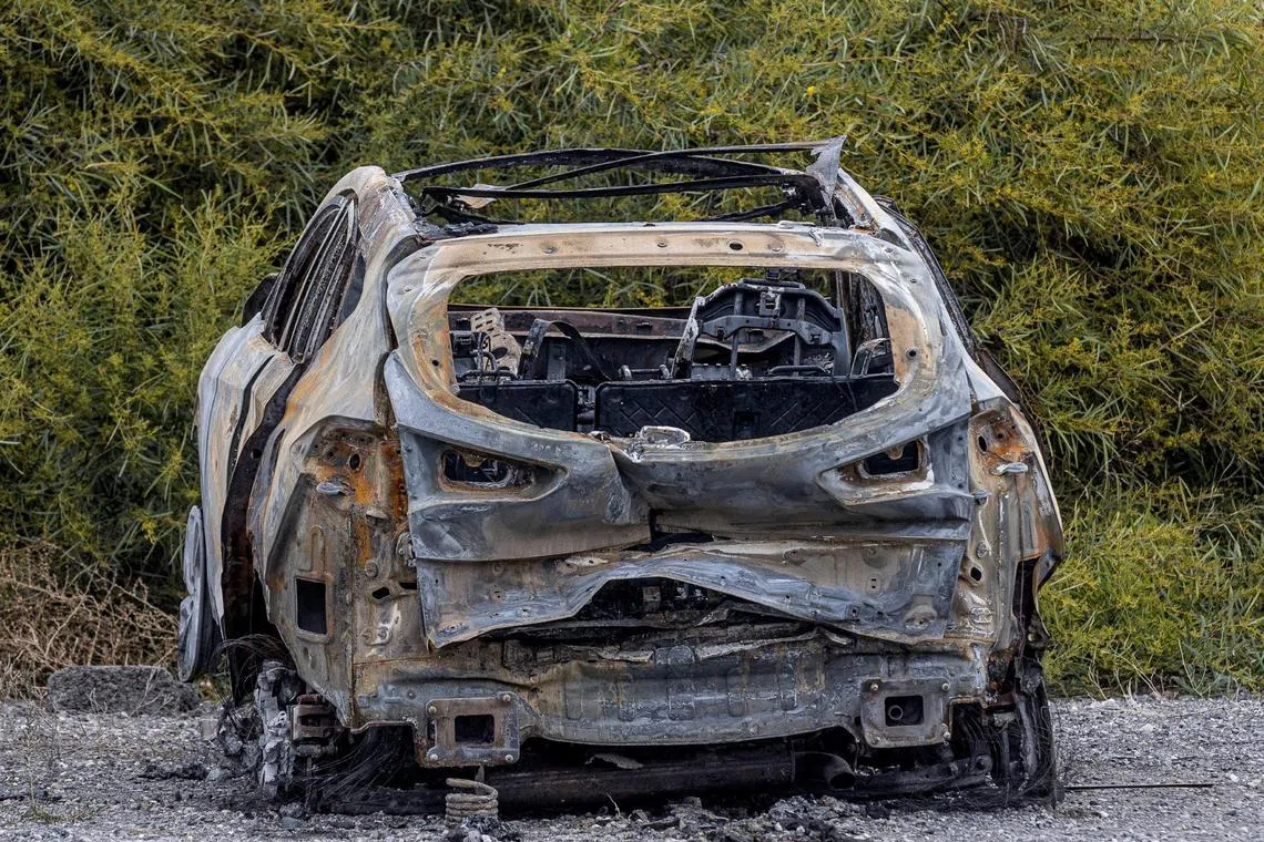 A burned car allegedly used by the murderers of Russian pilot Maxim Kuzminov  is parked outside the Spanish Civil Guard barracks, in El Campello, Spain.