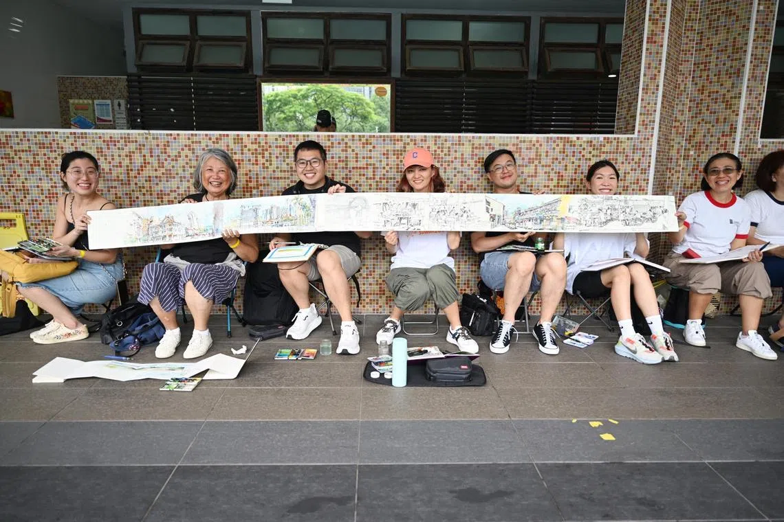 Tia Boon Sim (second from left), founder of Urban Sketchers Singapore (USKSG), with her members at Toa Payoh Swimming Complex. 

Members of Urban Sketchers Singapore (USKSG) holding up a piece of sketch done by Ms Tia Boon Sim (second from left), founder of USKSG. 