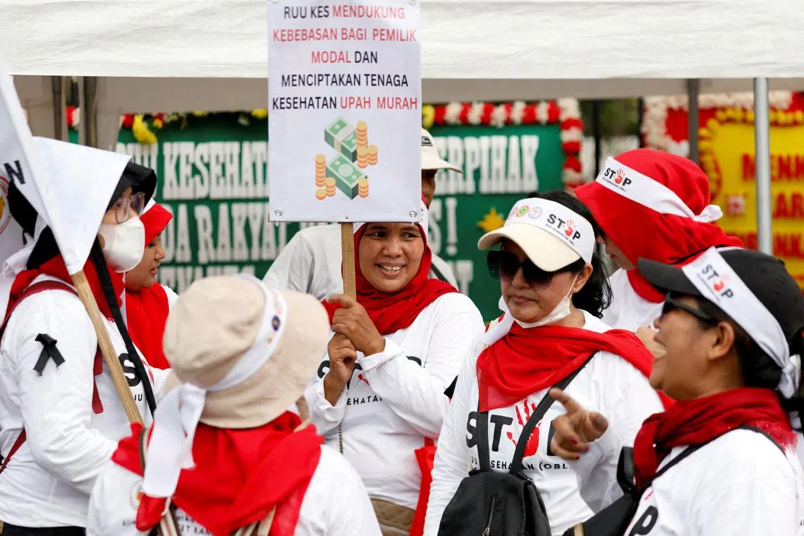 Health workers take part in a protest against a new health Bill outside the Indonesian Parliament building in Jakarta, on June 5.