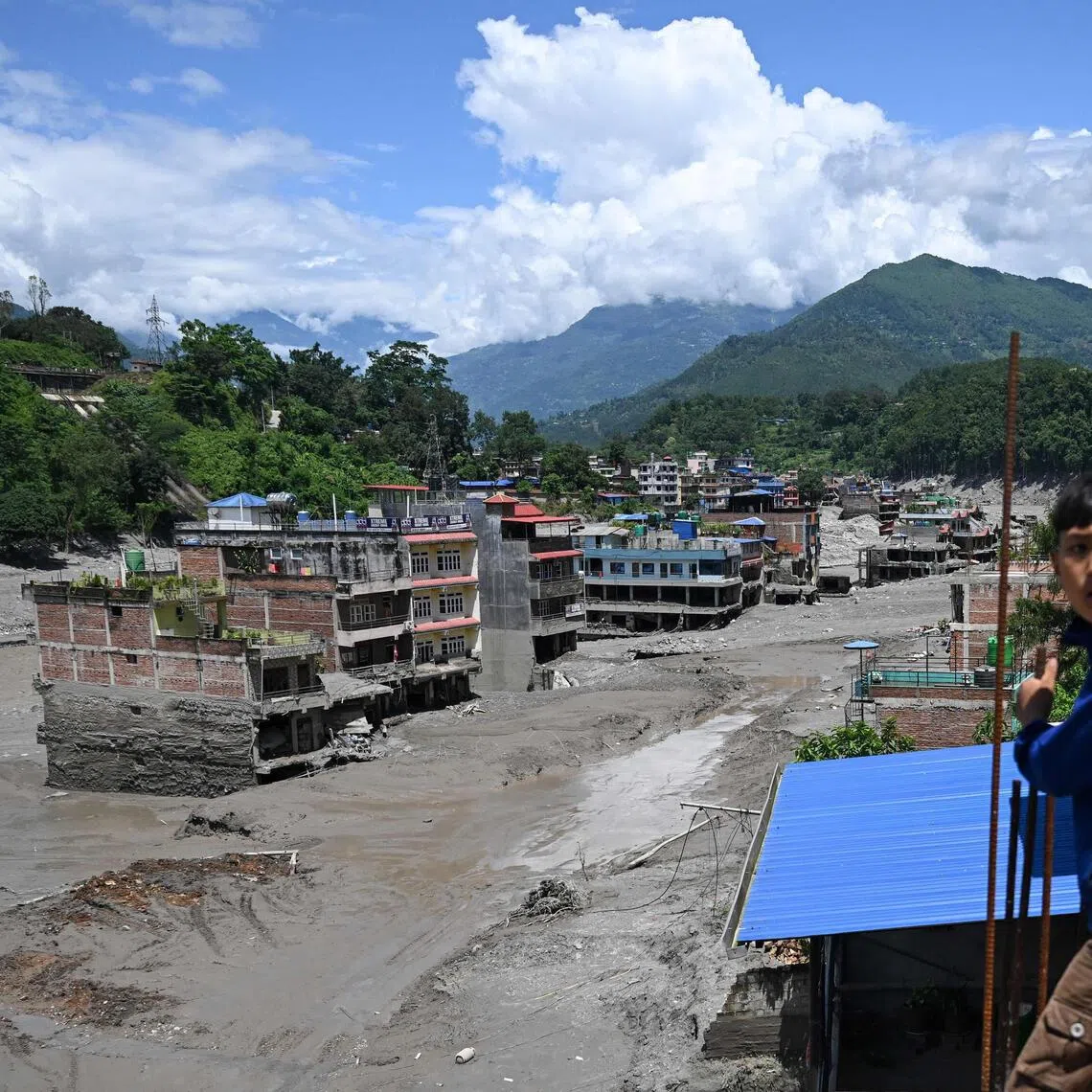 Houses lying deluged in sludge after flash floods at Trishuli in Nepal’s Nuwakot district on Aug 27.
