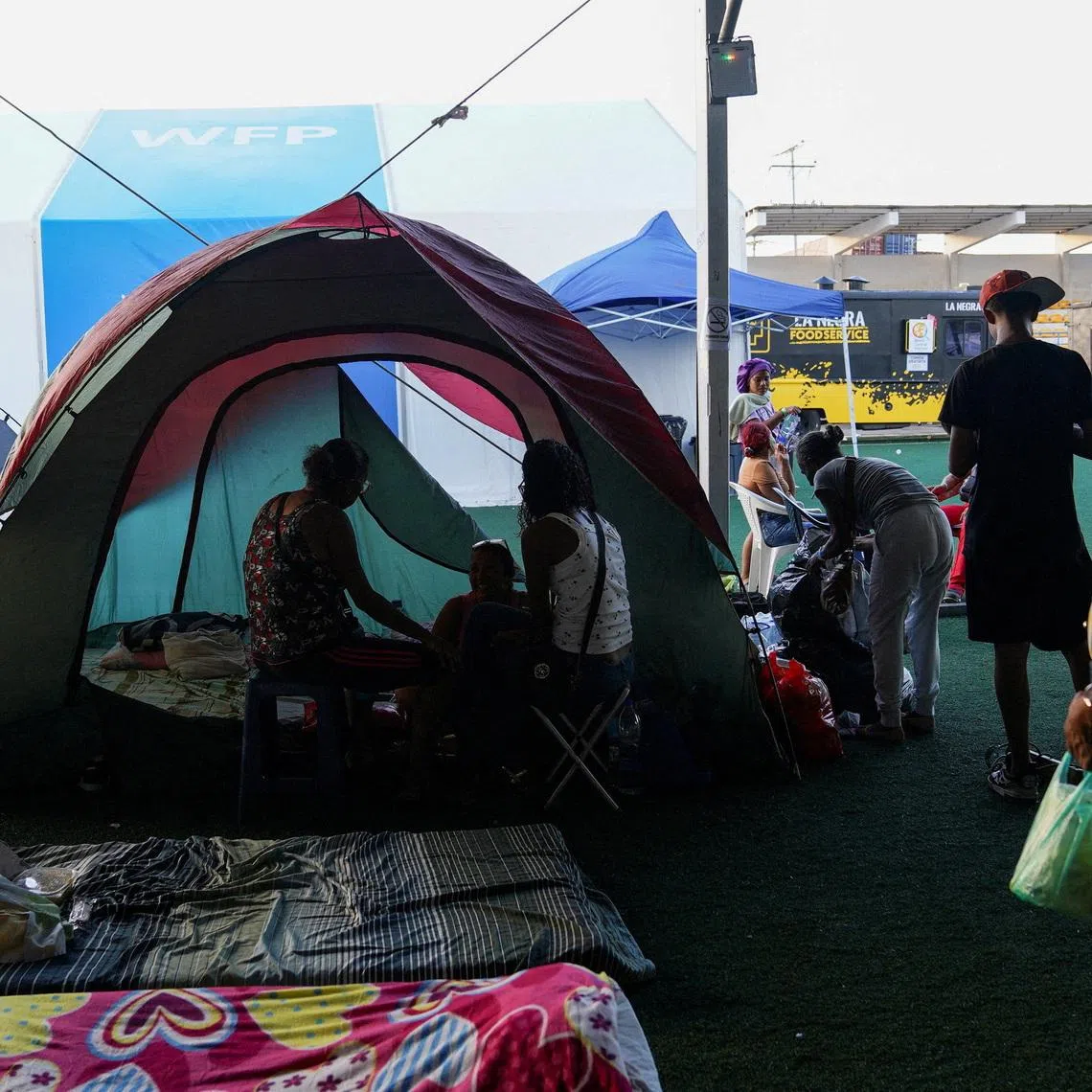 People gather near their tents at a makeshift shelter run by the UN, in the aftermath of the June 24 earthquakes, in La Guaira, Venezuela, on July 7.