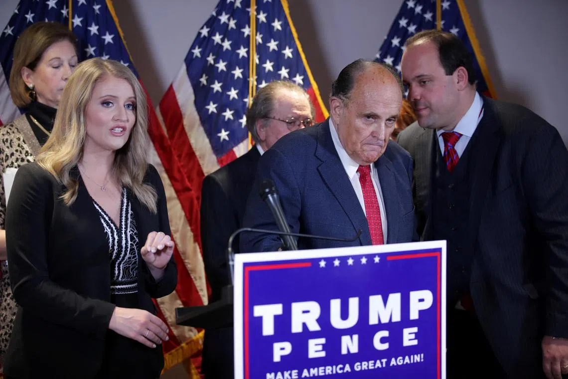 FILE PHOTO: Trump Campaign Senior Legal Advisor Jenna Ellis speaks as Trump campaign advisor Boris Epshteyn whispers to former New York City Mayor Rudy Giuliani, personal attorney to U.S. President Donald Trump, during a news conference about the 2020 U.S. presidential election results at Republican National Committee headquarters in Washington, U.S., November 19, 2020. REUTERS/Jonathan Ernst/File Photo