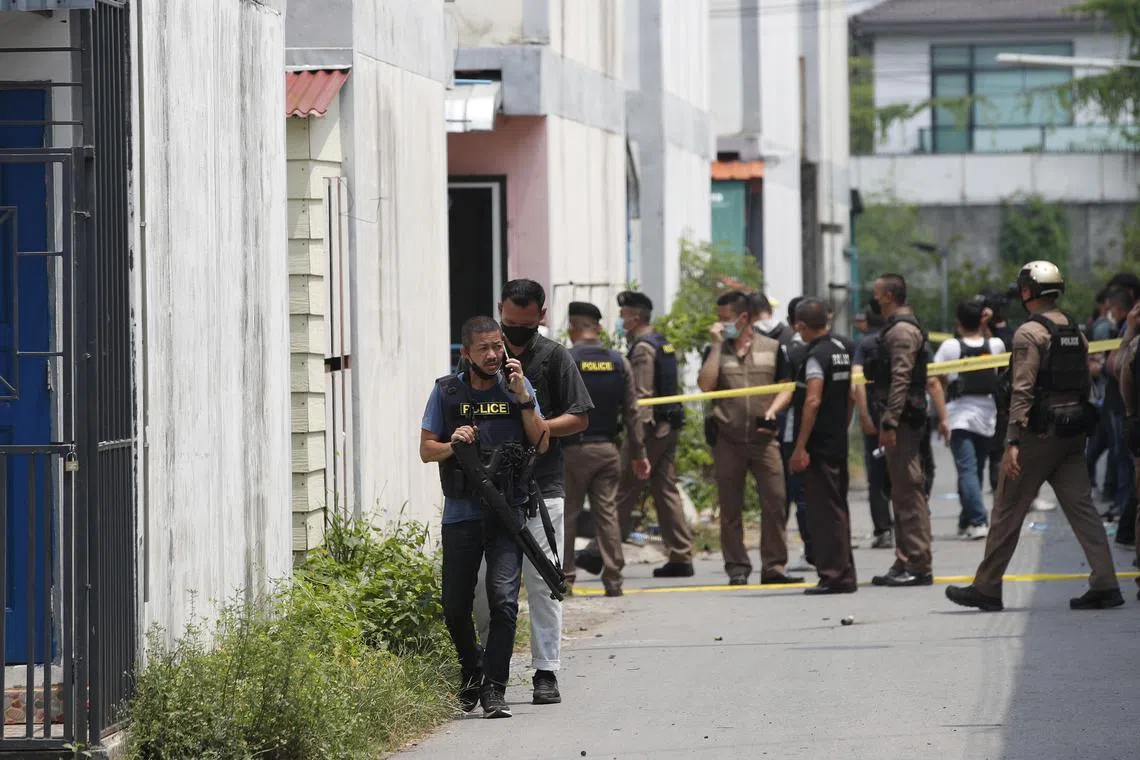 epa10523443 Thai police officers block off the area outside the house of a gunman, in the public area of Sai Mai district in Bangkok, Thailand, 15 March 2023. For more than 24 hours police were in a standoff in the area outside the house of a gunman, who is a police inspector with the intelligence unit of the Special Branch Police, after he became disgruntled and fired multiple shots in a residential public area on 14 March. The gunman was finally was arrested and there were no injuries reported in the incident, police said.  EPA-EFE/RUNGROJ YONGRIT