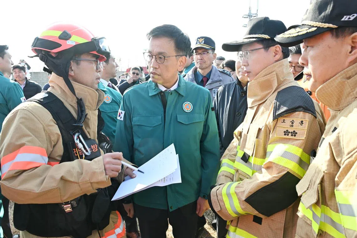South Korea’s Acting President Choi Sang-mok (second from left) speaking to firefighters during a visit to the site of the plane crash.