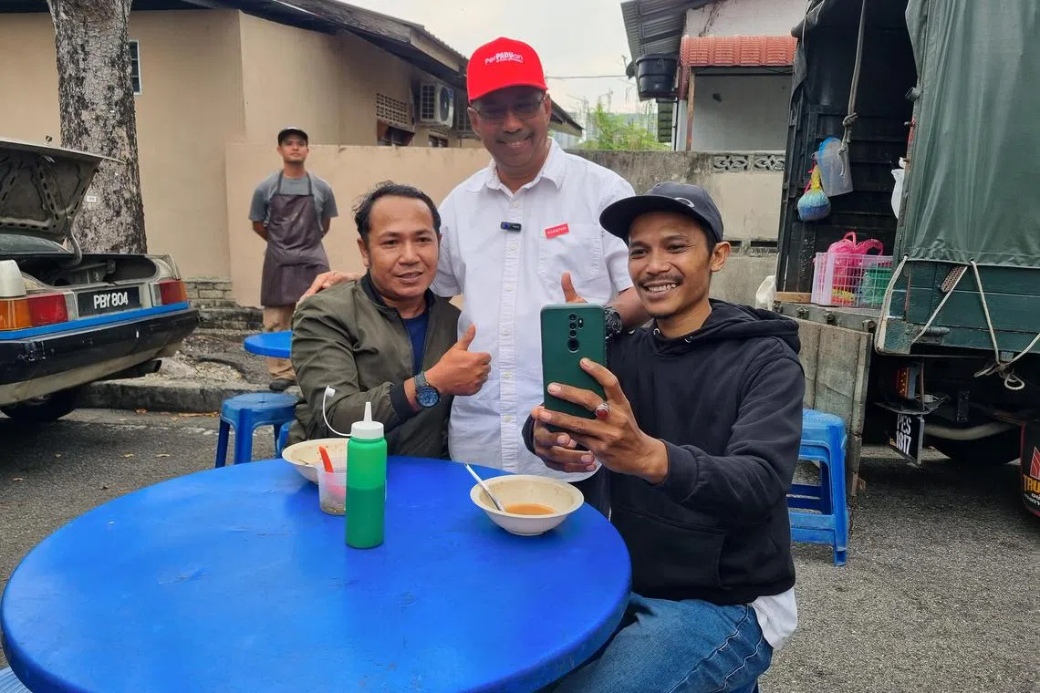 enpenang - Pakatan Harapan (PH) candidate Johari Kassim for the Seberang Jaya state seat (middle) taking selfies with voters at a pasar malam.




Credit: Eileen Ng