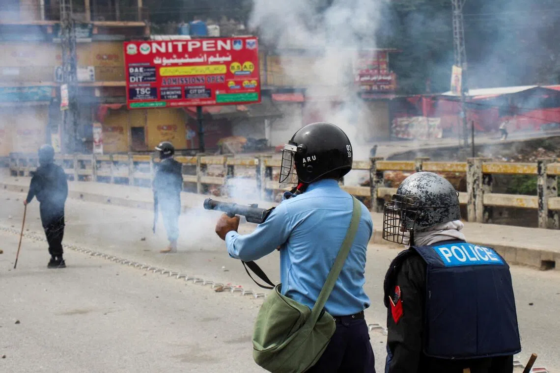 A police officer fires tear gas to disperse the protesters during a protest in Muzaffarabad, the capital of Pakistan-administered Kashmir.

