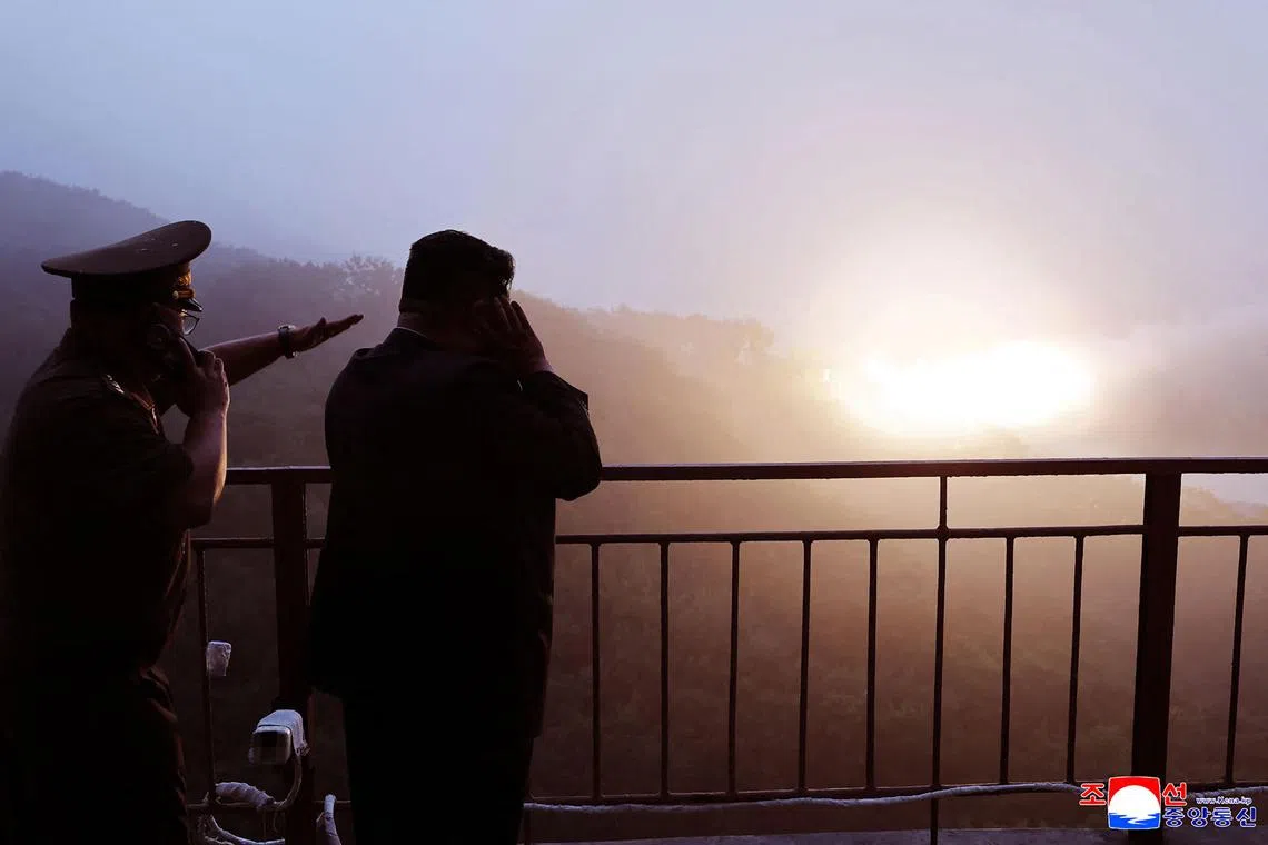 North Korea's leader Kim Jong Un (right) inspecting the ground combustion of a high-thrust solid fuel engine using carbon fibre composites, at an undisclosed location in North Korea. 