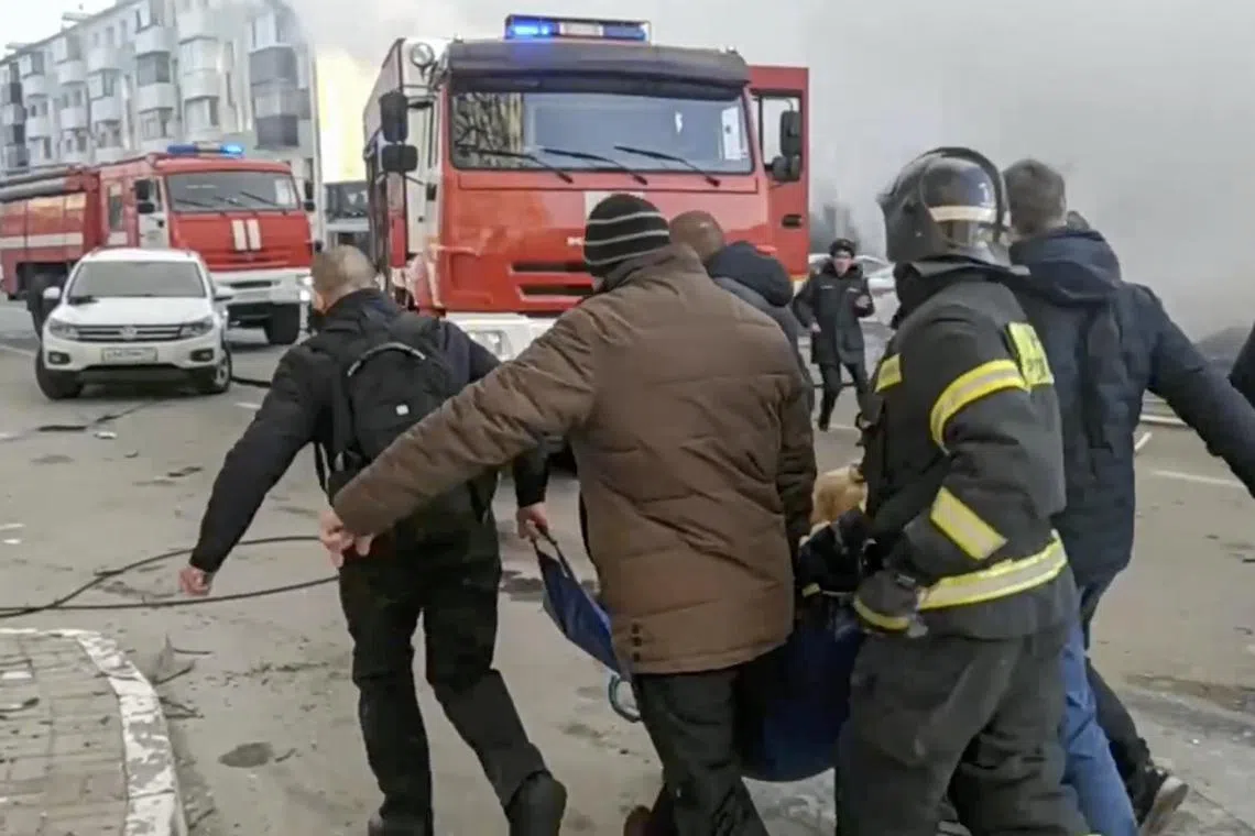 Russian rescuers carry an injured woman after shelling in Belgorod, Russia, in a handout photo.