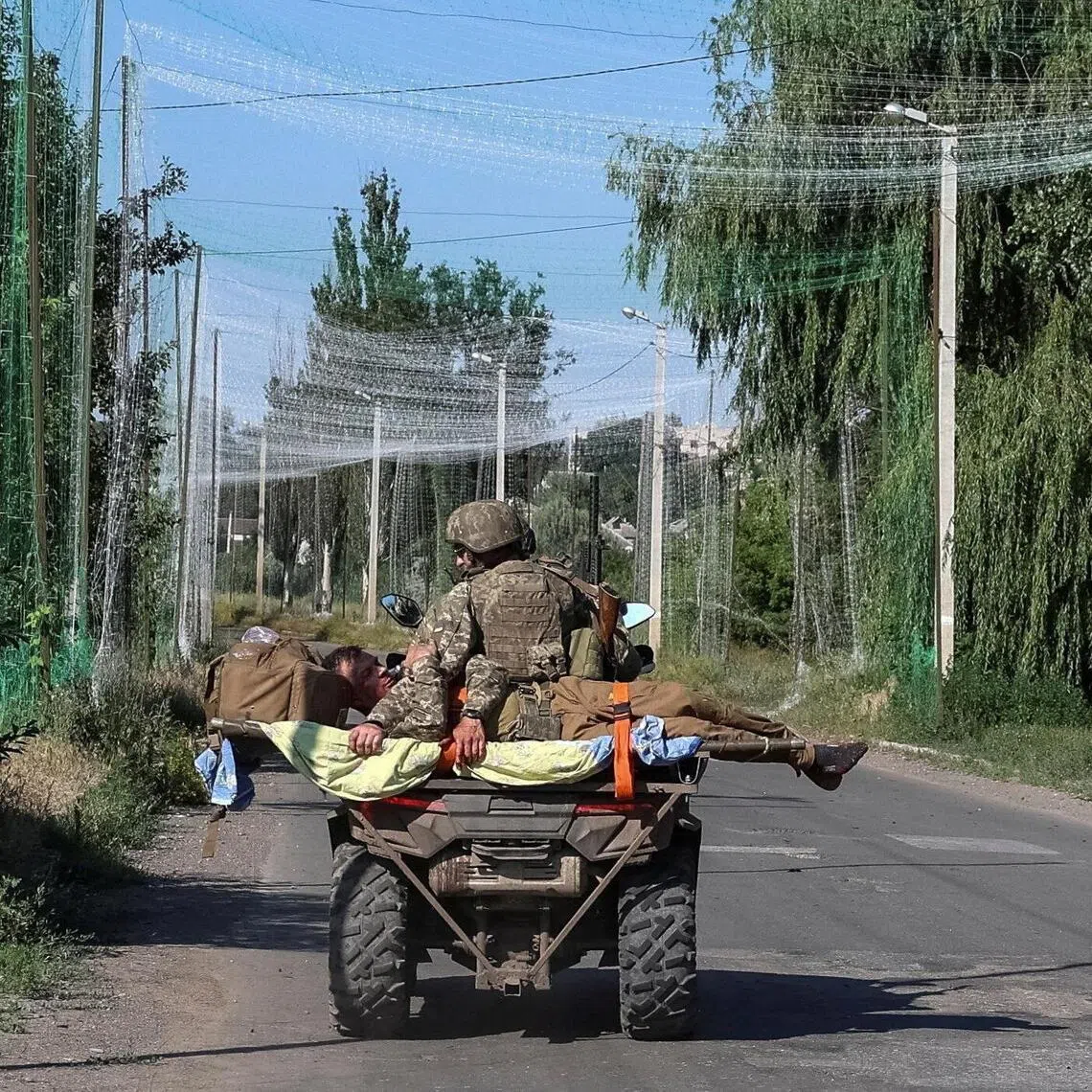 Ukrainian servicemen evacuate their wounded colleague, amid Russia's attack on Ukraine, at a frontline in Donetsk region, Ukraine July 1, 2026. REUTERS/Anatolii Stepanov     TPX IMAGES OF THE DAY