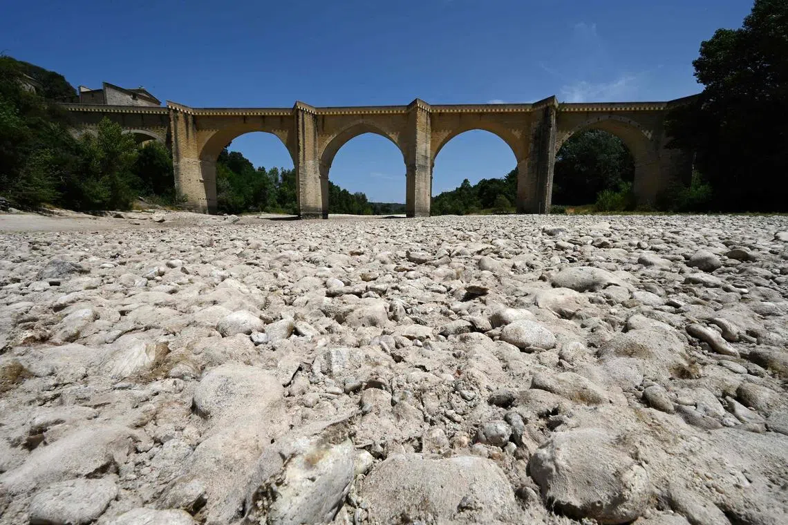 (FILES) In this file photo taken on June 20, 2022 A photograph shows the parched river bed of the Gardon near the Saint-Nicolas de Campagnac bridge in Saint-Anastasie, southern France, after a heat wave hit France, on June 20, 2022. - Earth is hotter than it has been in 125,000 years, but deadly heatwaves, storms and floods amplified by global warming could be but a foretaste as planet-heating fossil fuels put a "liveable" future at risk.o concludes the UN Intergovernmental Panel on Climate Change (IPCC), which has started a week-long meeting to distill six landmark reports totalling 10,000 pages prepared by more than 1,000 scientists over the last six years. (Photo by Pascal GUYOT / AFP)