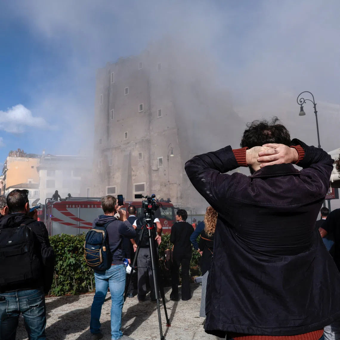 Onlookers watch as dust rises following collapses of parts of the Torre dei Conti, near Via dei Fori Imperiali, near the Colosseum, in Rome, Italy, November 3, 2025. REUTERS/Remo Casilli
