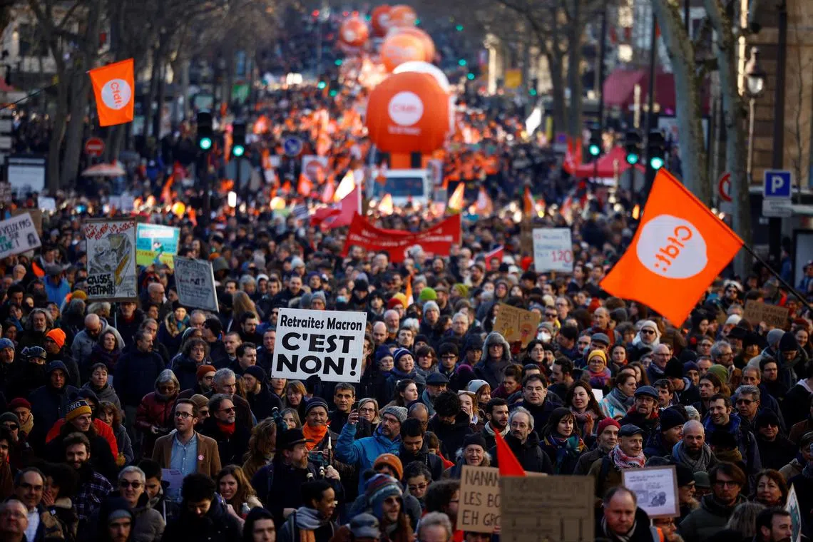 Protesters during a demonstration against the French government's pension reform plan in Paris as part of the third day of national strike and protests in France on Feb 7, 2023. The slogan reads "Macron's pensions reform, it's no".