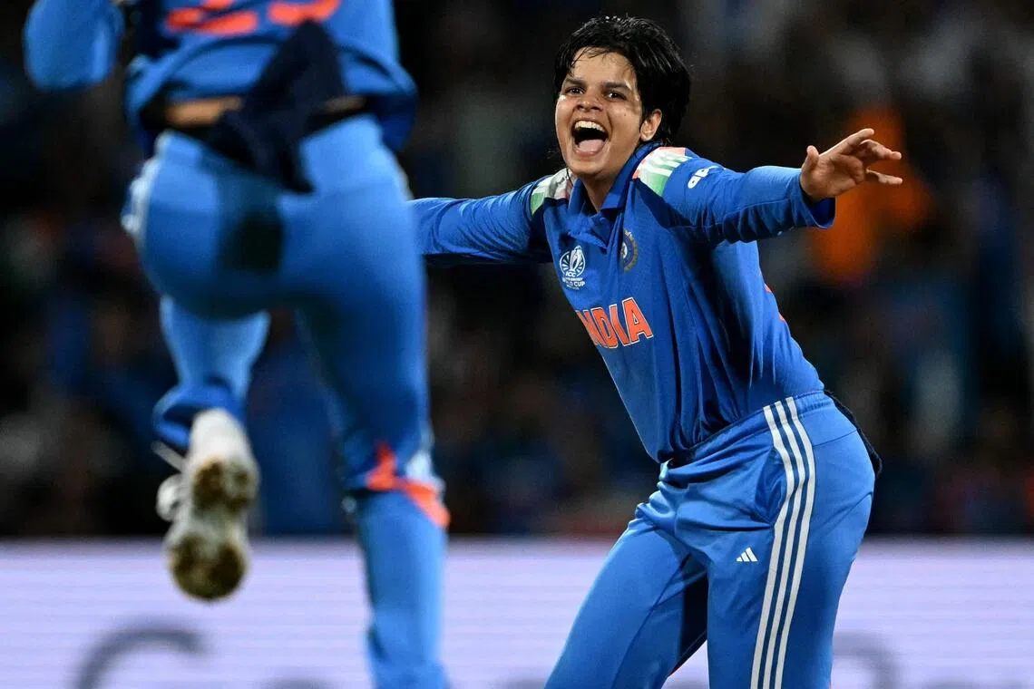 India's Shafali Verma (right) celebrating with her captain Harmanpreet Kaur after taking the wicket of South Africa's Sune Luus during their Women's Cricket World Cup final win on Nov 2.