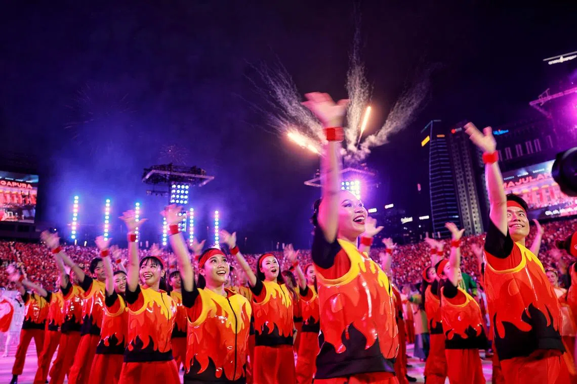 Participants waving during the National Day Parade at the Padang on Aug 9, 2023. ST PHOTO: KEVIN LIM