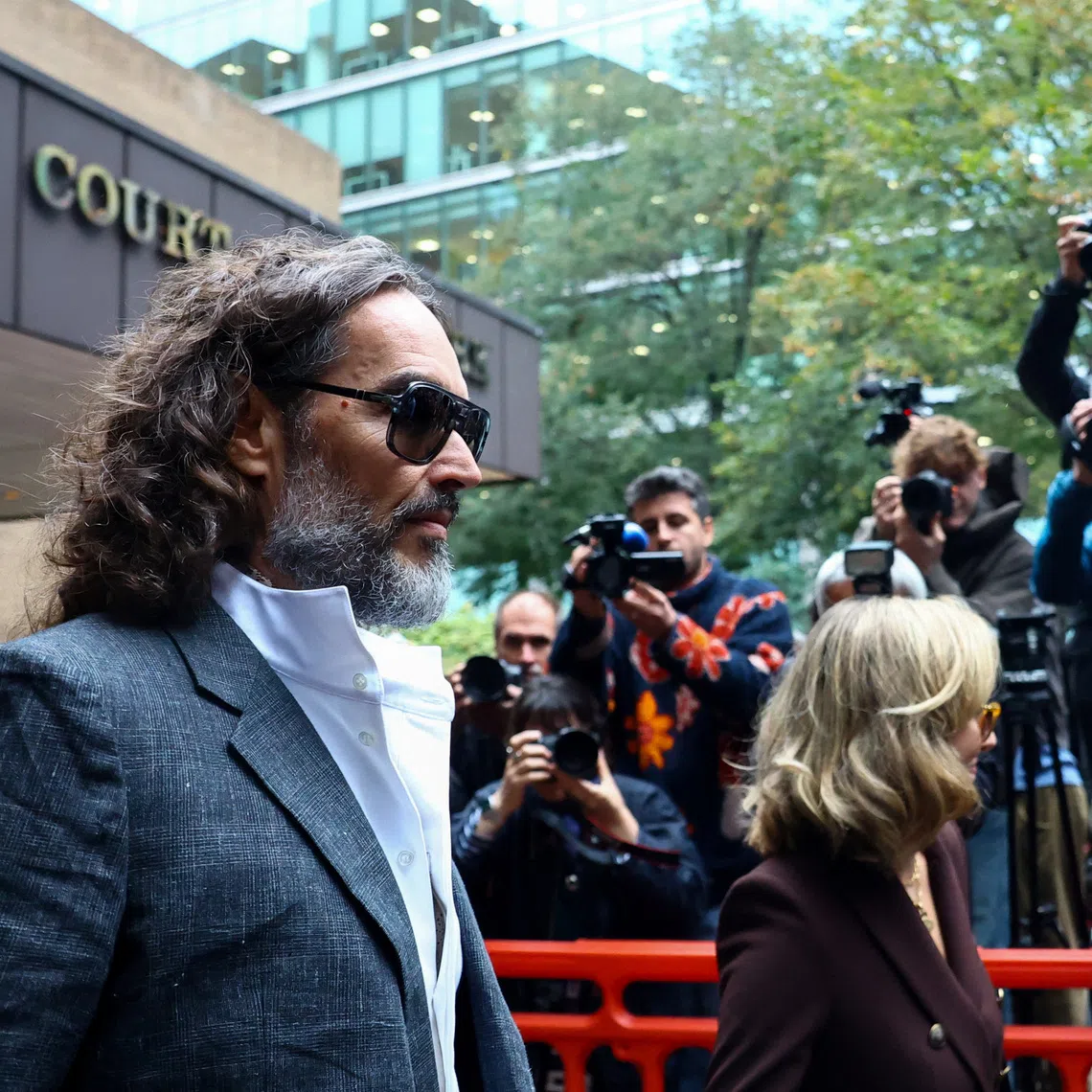 British actor and comedian Russell Brand and his wife Laura Brand leave Southwark Crown Court, where he is standing trial on charges of rape and sexual assault relating to six women, which he denies, in London, Britain, October 12, 2026. REUTERS/Hannah McKay