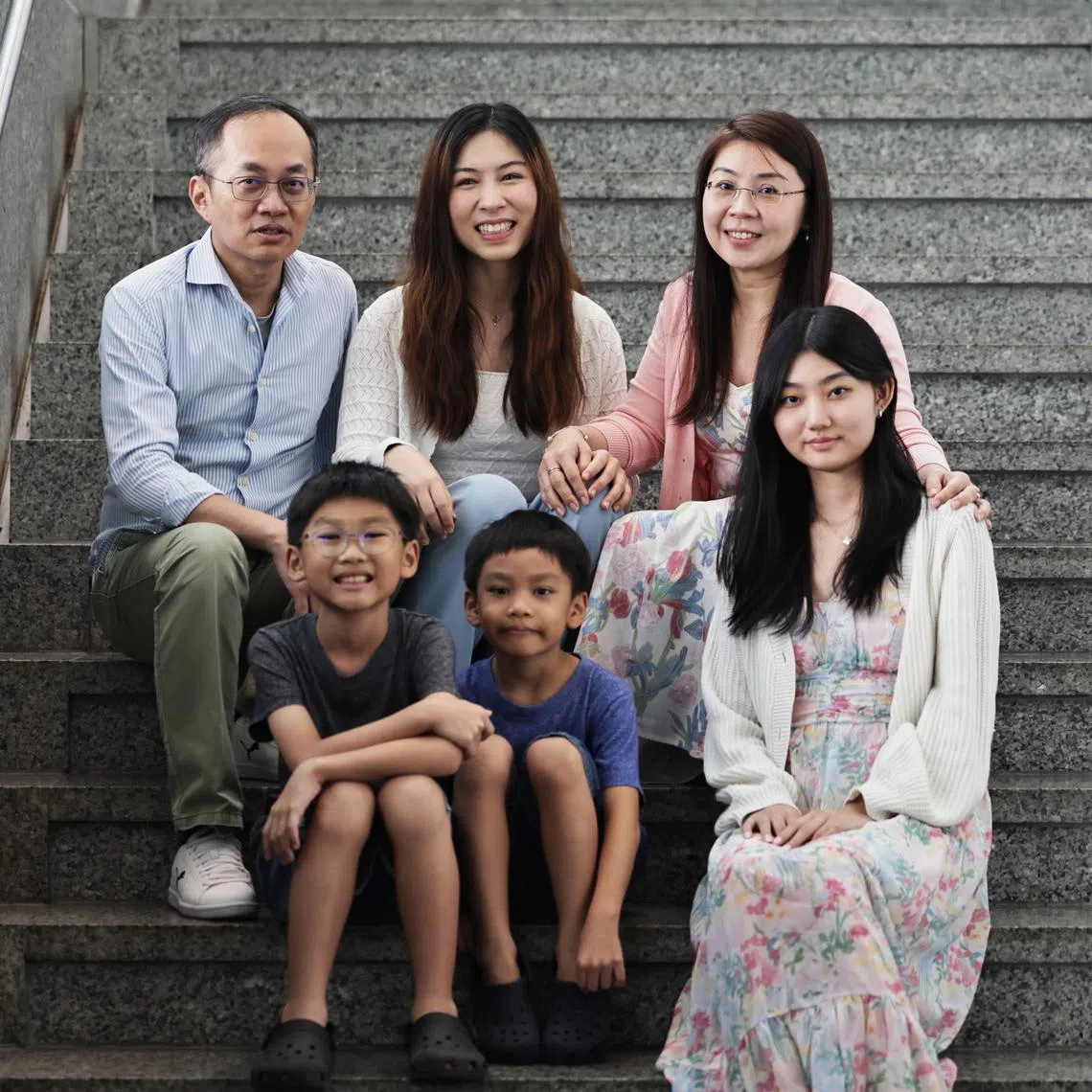 Ms Pauline Dominique Ching Alejado (back, centre) with her foster parents Mr Jason Gwee and Madam Irene Leow. Also pictured are the couple’s children – (from left) Joshua Gwee, Jairus Gwee and Chloe Gwee.