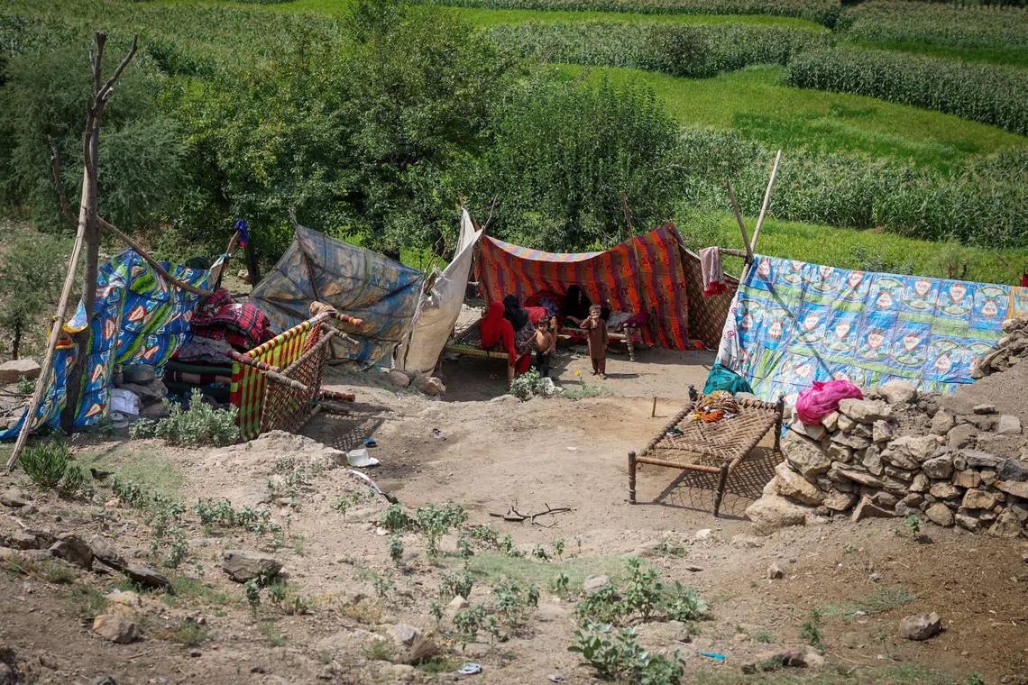 An Afghan family sits inside a makeshift shelter following a deadly magnitude-6 earthquake that struck Afghanistan on Sunday, at Lulam village, in Nurgal district, Kunar province, Afghanistan, September 3, 2025. REUTERS/Sayed Hassib