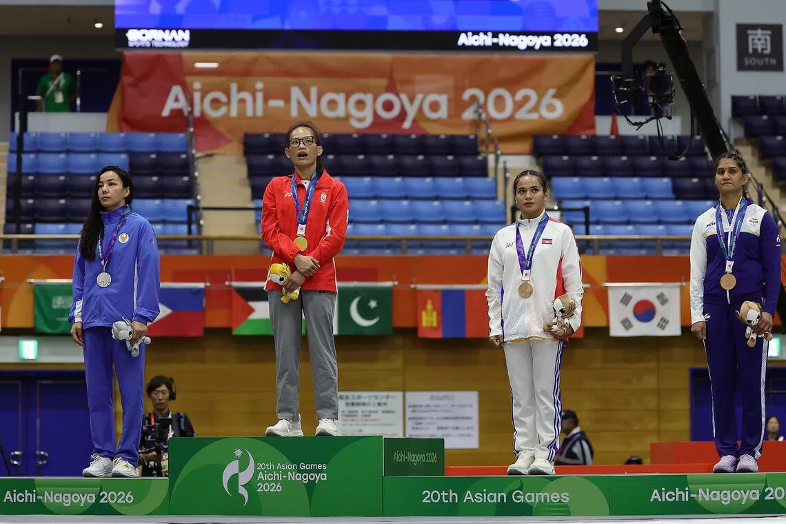 ST20260922_202642400743/ pixag22/ Kevin Lim// Gold medalist Tiffany Teo (second from left) of Singapore singing the national anthem on the podium after winning the mixed martial arts women's traditional (60kg) final of the Aichi-Nagoya 2026 Asian Games at the Nagoya City Inae Sports Centre in Nagoya, Japan on Sept 22, 2026. On the podium with Tiffany are (from left) silver medalist Khilola Sobirova of Uzbekistan, and bronze medalists Cheng Dalin of Cambodia and Suchika Tariyal of India. ST PHOTO: KEVIN LIM pixag22
