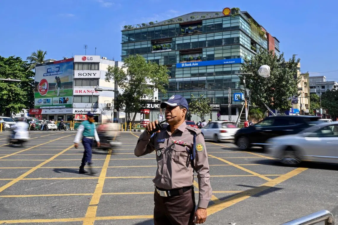 This photograph taken on Nov 16 shows a Bangladesh Police personnel wearing the newly introduced iron-grey shirt and chocolate-brown trouser uniform as he stands guard along a road in Dhaka. 