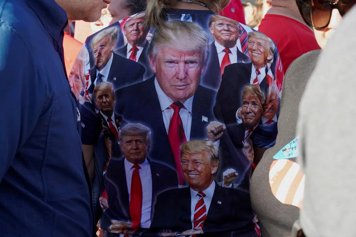 A supporter wears a shirt featuring images of former US president Donald Trump at a rally in Texas.