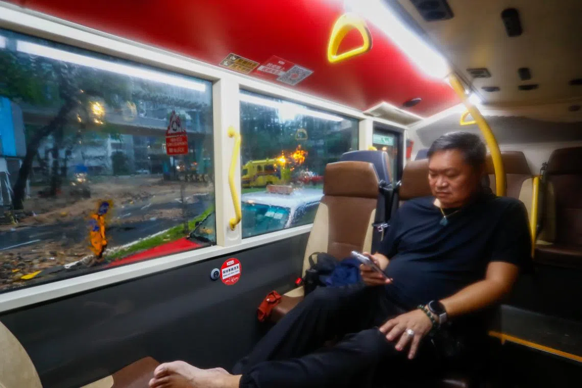 A bus driver seeking shelter inside his damaged bus following continued torrential rains hitting the city, in Hong Kong, China, Sept 8, 2023. 