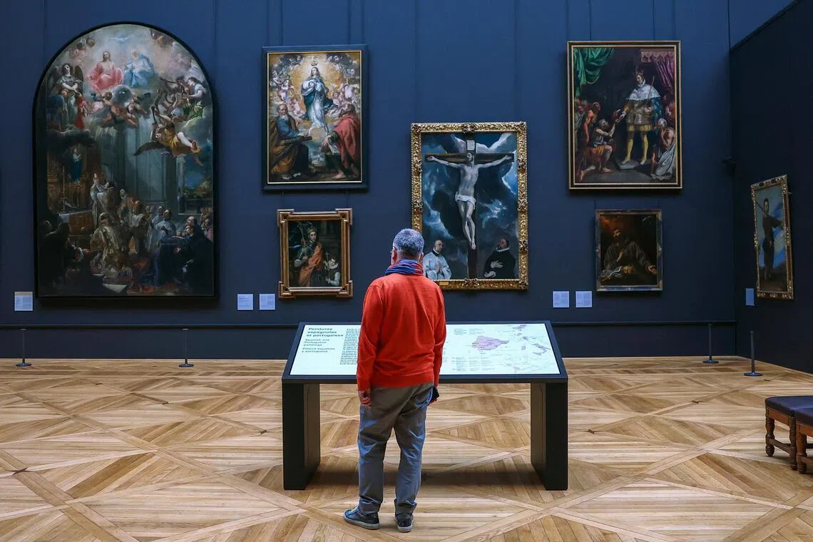 A man looking at paintings at the renovated 17th century Spanish gallery in the Denon wing at the Louvre Museum in Paris on Dec 2, 2025. The Denon gallery houses its most valuable paintings. 