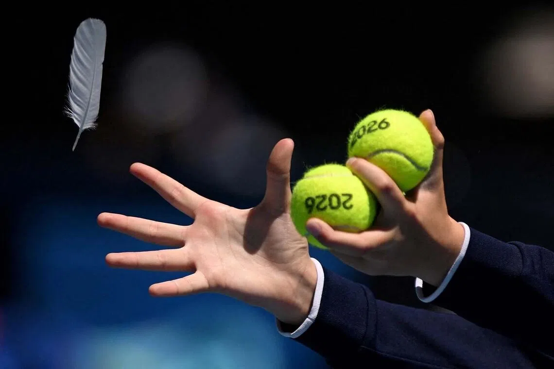 A ball kid catching a feather during an Australian Open quarter final match between Aryna Sabalenka and Iva Jovic in Melbourne Park, Australia, Jan 27, 2026.