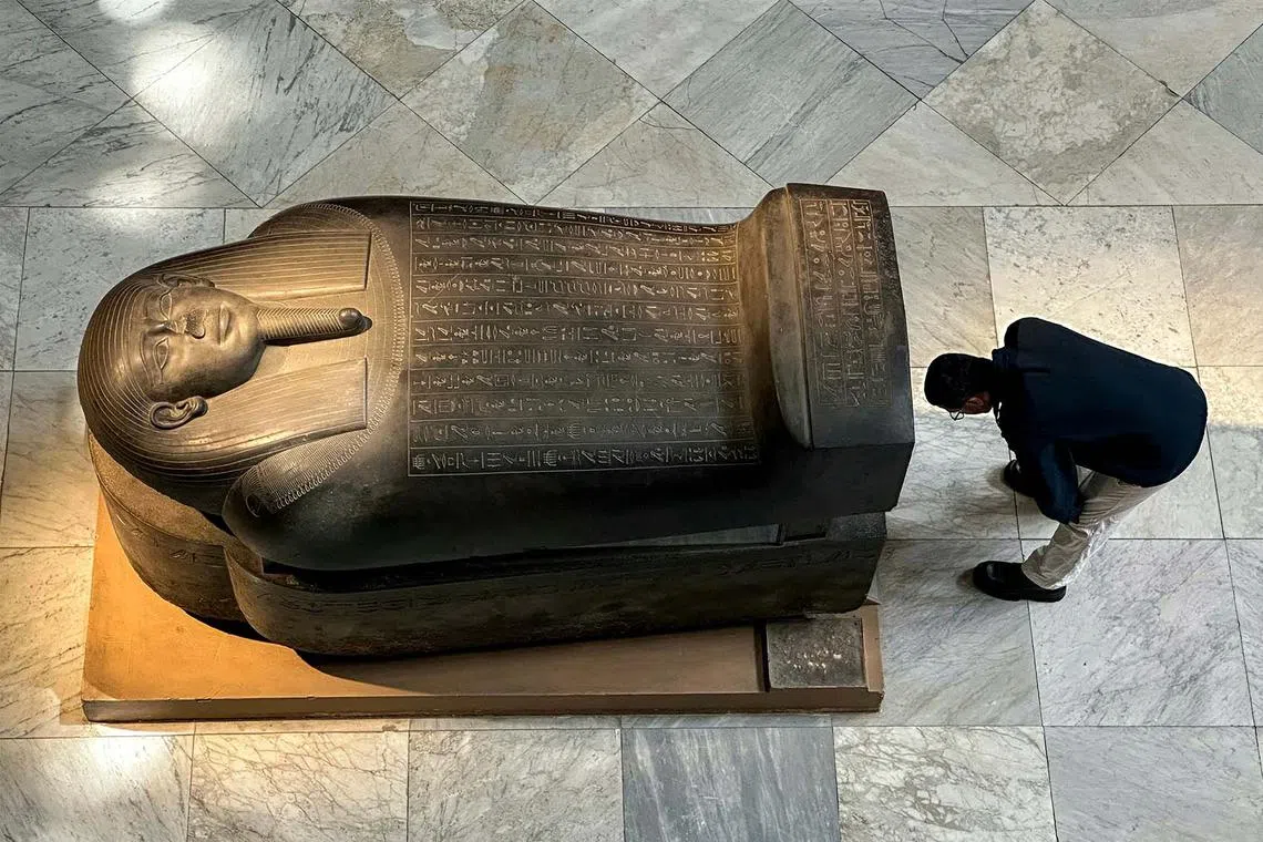 A man standing by the ancient Egyptian Late Period (7th-4th century BC) stone sarcophagus of Ahmose-pen at the Egyptian Museum in Cairo's central Tahrir Square on June 11, 2025.