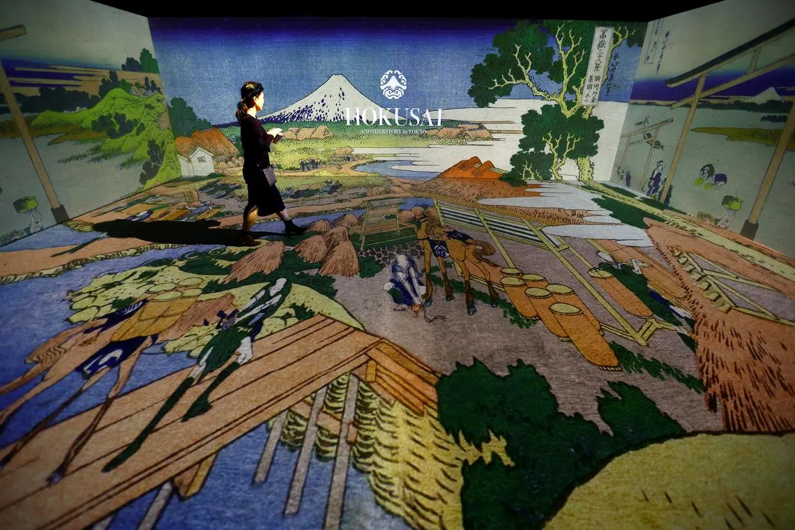A visitor attends an exhibition that uses cutting-edge technology to bring to life the work of iconic samurai-era ukiyo-e artist Katsushika Hokusai at 'HOKUSAI: ANOTHER STORY in TOKYO', technical wizardry from Sony PCL Inc. and Ars Techne Corp, and the woodblock prints provided by the Yamanashi Prefectural Museum that owns the original work, during a preview event in Tokyo, Japan January 30, 2025.  REUTERS/Issei Kato