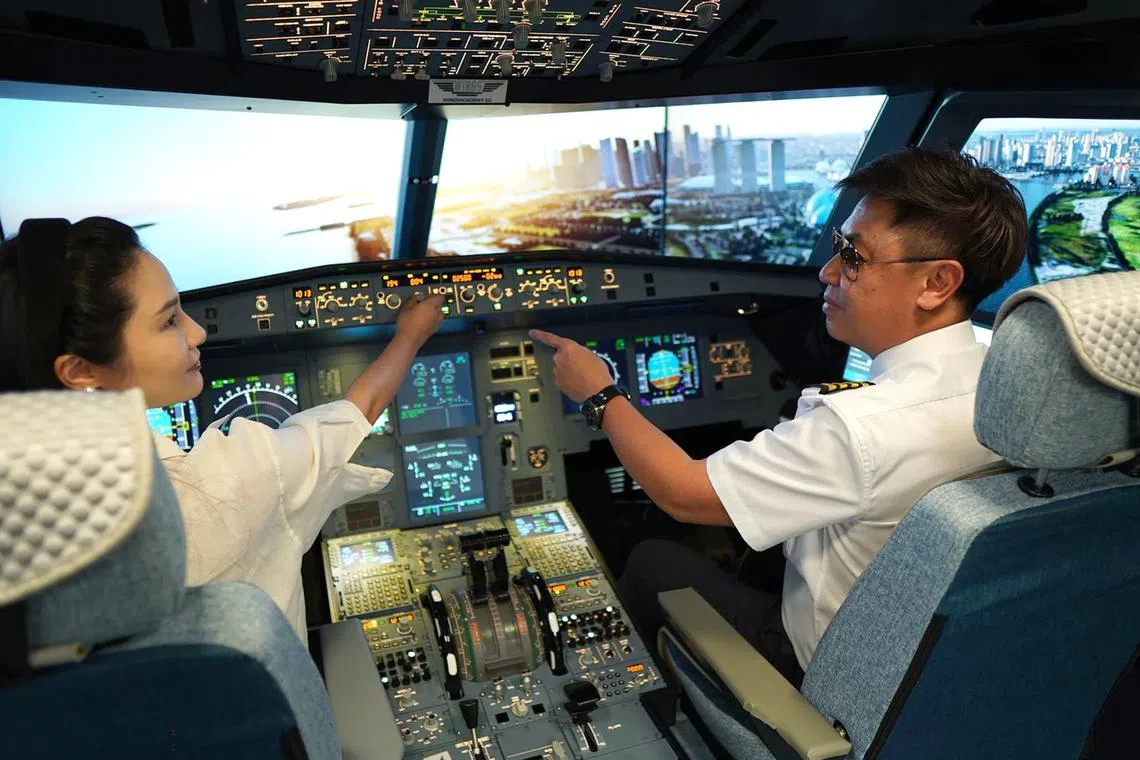 A flying instructor teaching a student in an A320 flight simulator at WingsAcademy.sg.