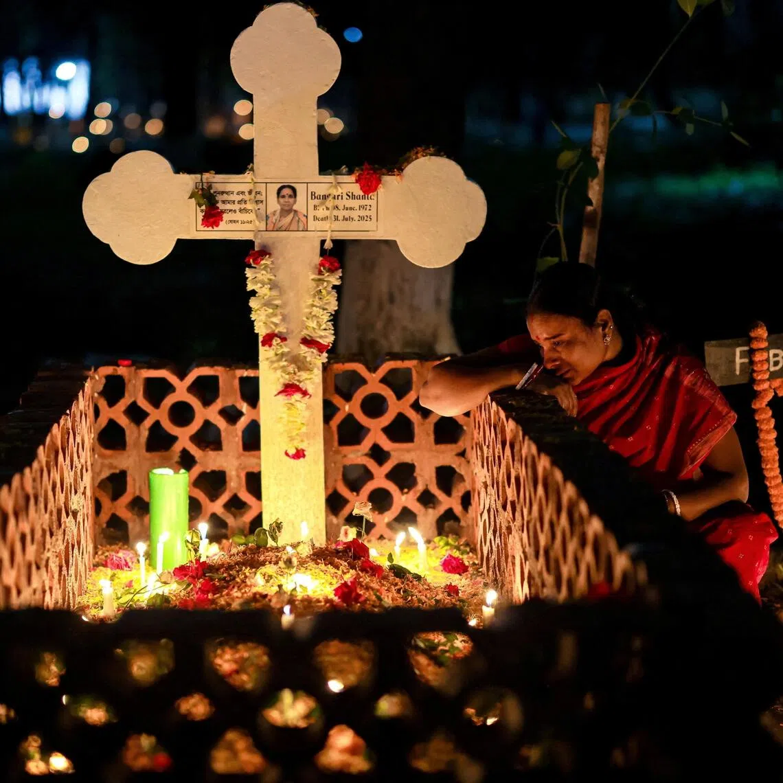 A woman mourns while sitting next to a grave as members of Bangladesh’s Christian community observe All Souls Day.
