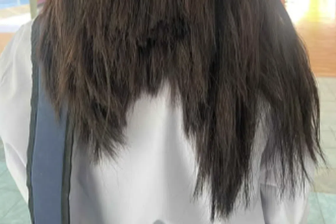 The student's hair was cut with paper scissors for not adhering to the school's hairstyle rules. 